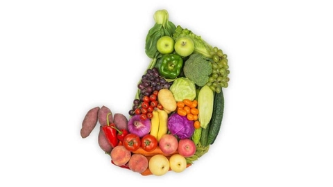 An image of vegetables and fruits put together in such a way that they form the shape of a digestive system 