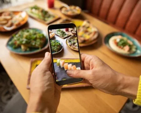 an image of a person clicking picture of food kept in front