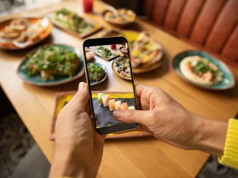 an image of a person clicking picture of food kept in front