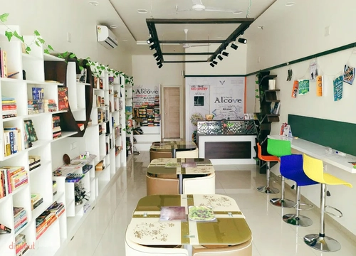 Photo of interior of Aclove - The Book Cafe. Cafe is full of books and is designed in colours with stationary items.