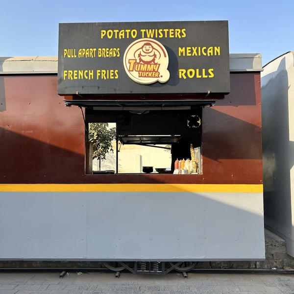 An image of Tummy Tucker's counter at Bogie Chefs featuring a black board with yellow text and a sumo wrestler in the logo.