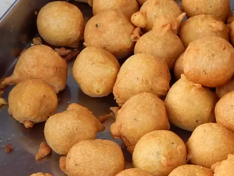 An image of golden brown crispy Bondas in a container | Best Veg Food In Pondicherry