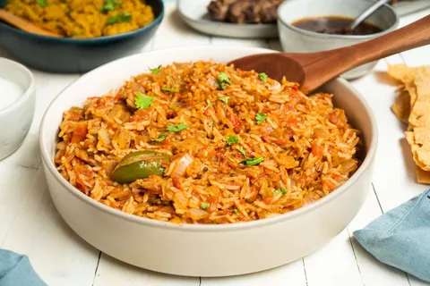 An image of Tomato rice or thakkali sadam in a round open container.