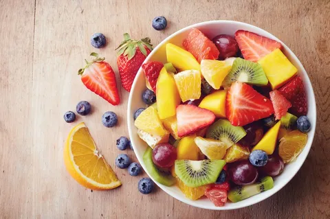 Image of high-fiber fruits in a bowl. There are some fruits on the floor as well,
