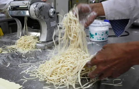 Noodles being made through hands anf machines.